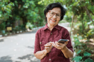 Older woman smiling holding cell phone